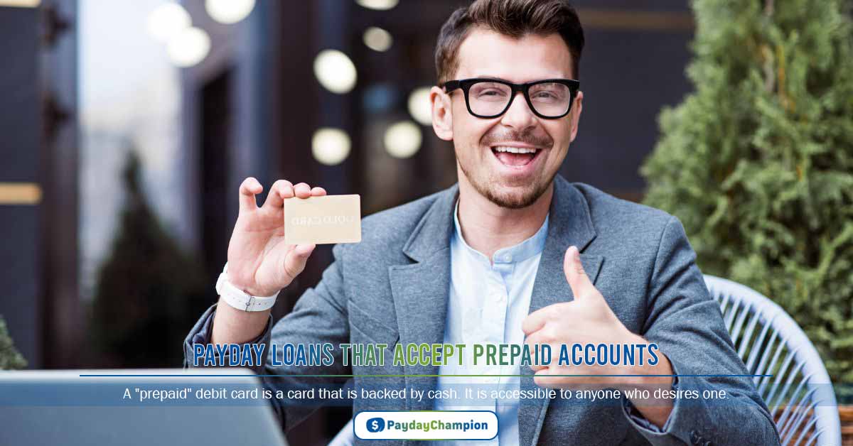 A man sitting at a table with a laptop giving a thumbs up for payday loans that accept prepaid accounts