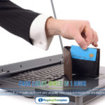 A person holding a credit card in front of a laptop applying for cash loans wired in 1 hour