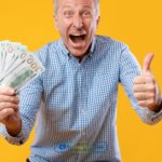 a person holding a dollar bill in their hand.