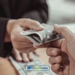 a person handing money to another person.