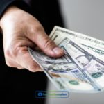 a person handing money to another person.