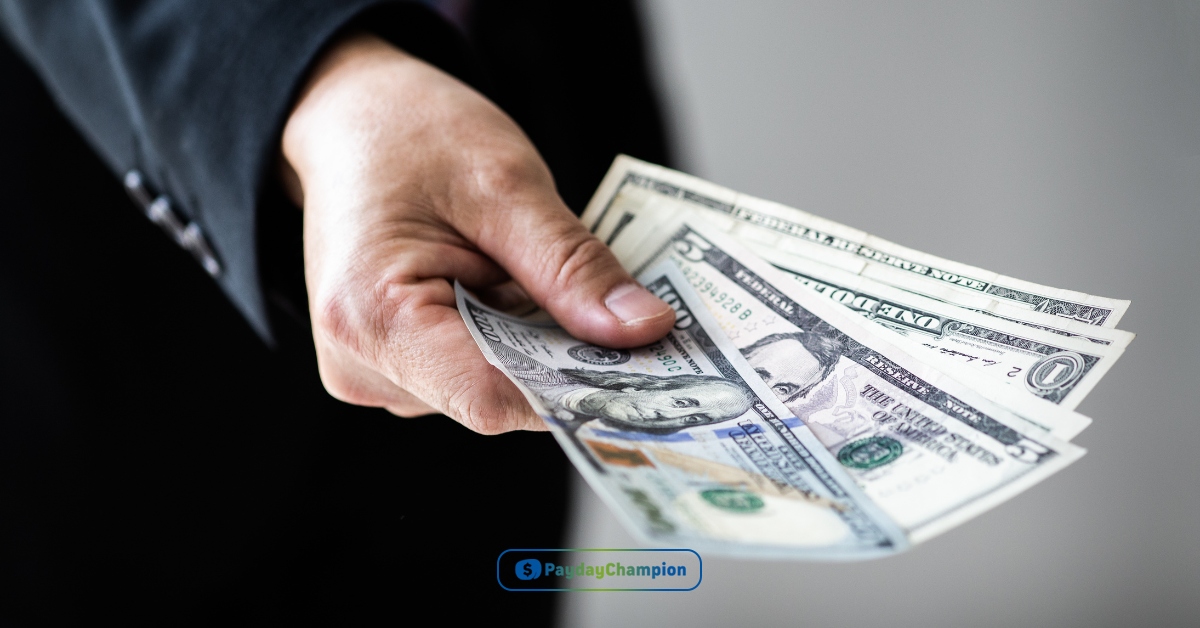 A person in a suit holding a stack of installment loans money in West Virginia