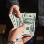 a person handing money to another person.