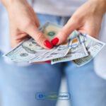 A woman holding a bunch of money from installment loans online in Kentucky in her hands