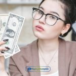 A woman holding installment loans money & phone in their hand in New Mexico