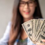 A woman holding a stack of money from installment loans in Florida in her hand