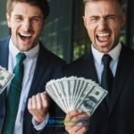 Two people holding dollar bills from installment loans Idaho in their hands