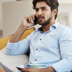 A man sitting on a couch searching for unsecured auto loans using his cell phone