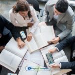 A group of borrowers with co-signers sitting around a table discussing the pros and cons of the loan