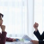 Two women sitting at a table talking to each other about payday loans Indianapolis