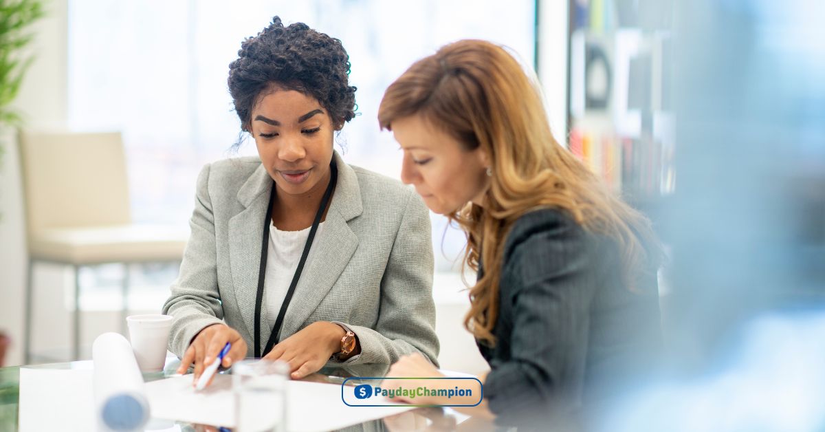 Two women sitting at a table looking at a piece of paper reading about payday loans in Las Vegas