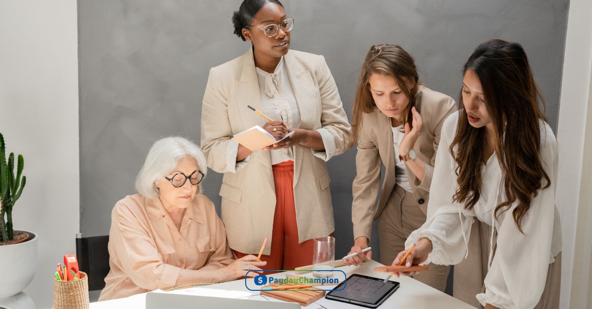 A group of women standing around a table analyzing payday loans Memphis