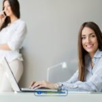 A woman sitting in front of a laptop computer typing payday loans Philadelphia