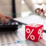 a red dice sitting on top of a table next to a calculator